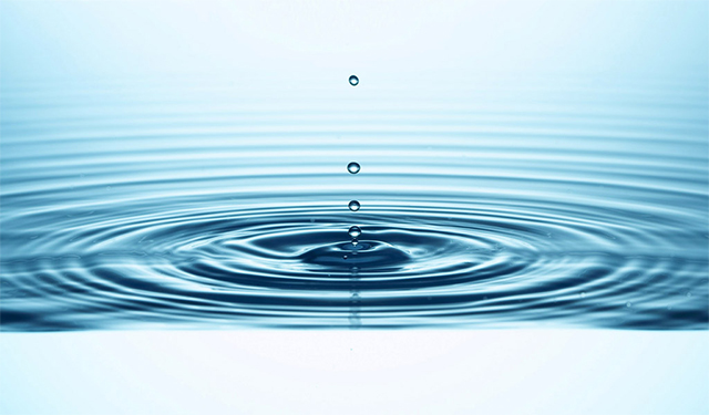 El impacto de una gota de agua causa un rebote rodeado de ondas capilares Agua