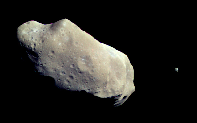El asteroide Ida y su diminuto satélite Dactyl. Algunos autores han sugerido que sería propicio para la minería. Imagen de la sonda Galileo, 1993  Asteroide Ida